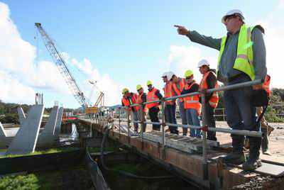Franco Meyer, an Environmental Monitoring Officer with the Northland Regional Council, points out sediment control measures to seminar participants during a visit to the new Hatea River bridge construction site in Whangarei yesterday. 